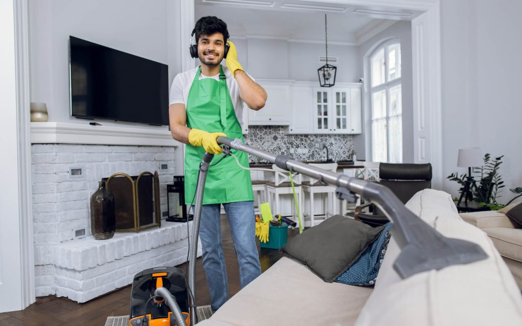 smiling-man-cleaning-sofa-and-listening-music-2021-12-09-06-25-39-utc.jpg